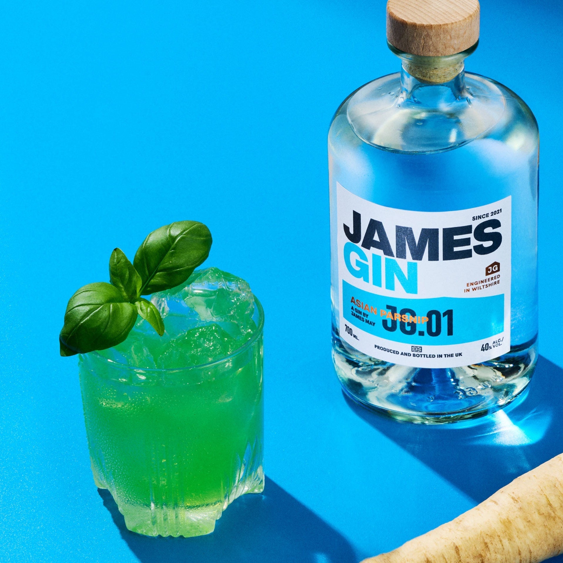 Bottle of James Gin asian parsnip alongside a green cocktail and a parsnip being measured by a calipers