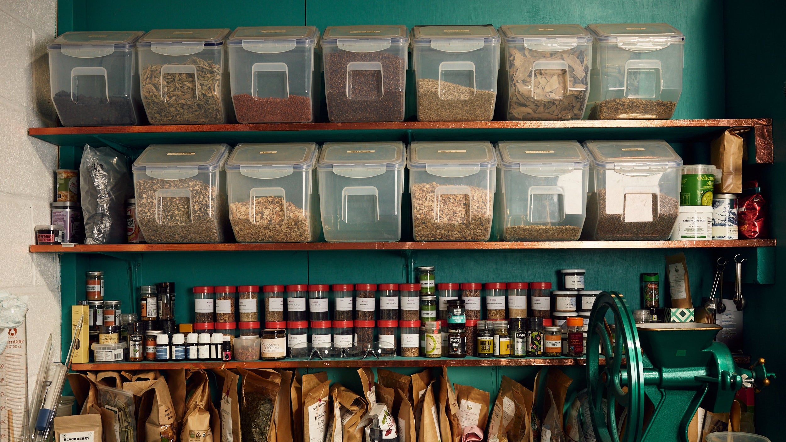image of shelves with buckets and jars of ingredients used for the gin inside the shed