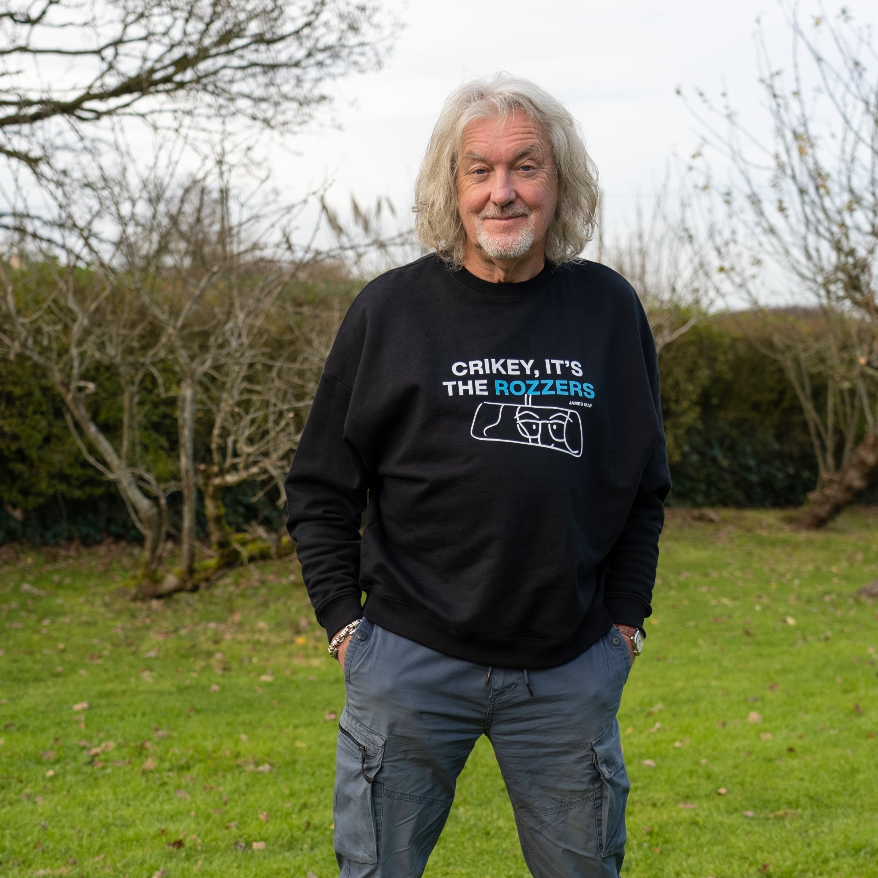 James May wearing his "crikey it's the rozzers" crewneck standing and smiling