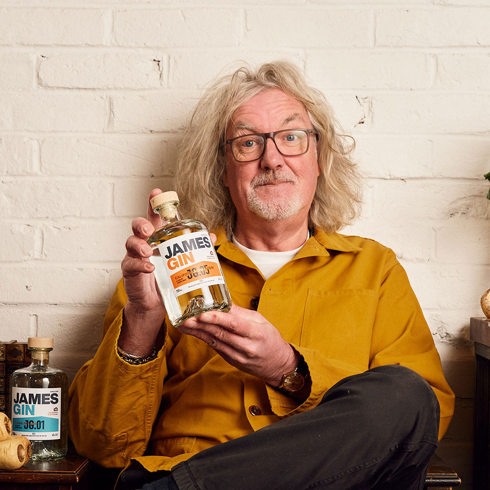 James May holding a bottle of his James Gin California Dreamgin' – premium gin by James May, produced and bottled in the UK.