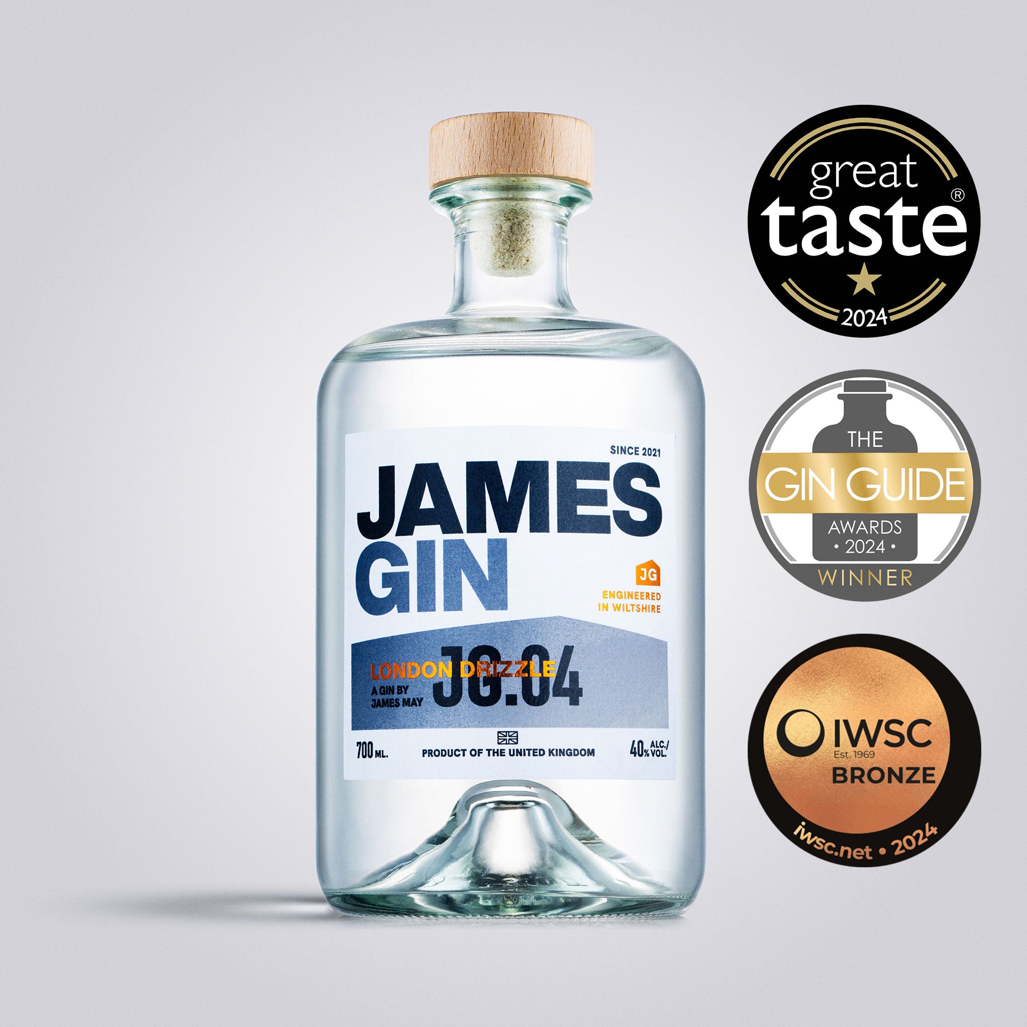 Bottle of James Gin London Drizzle with awards on a light gray background