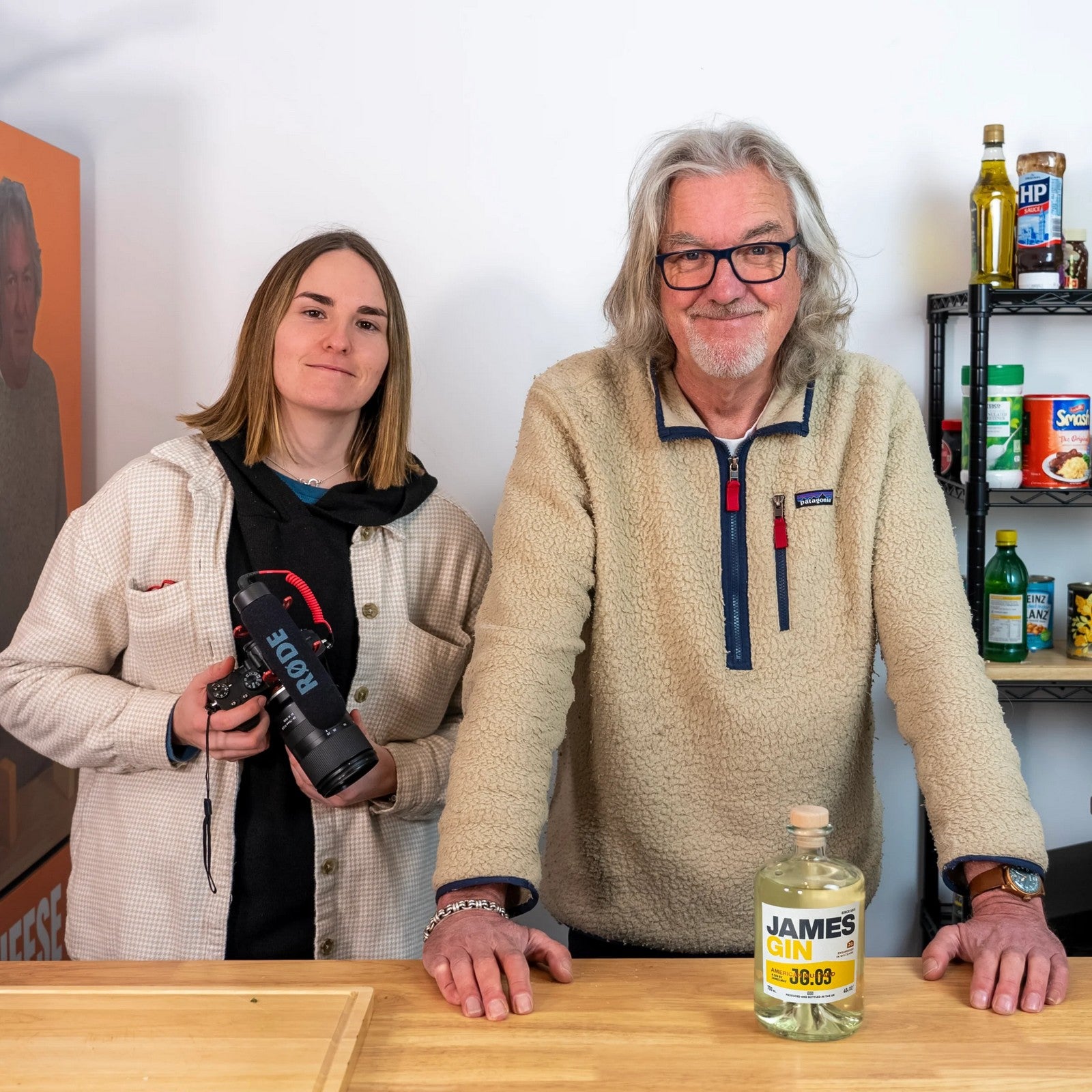 James May and Lucy Brown standing behind the Planet Gin counter with a bottle of James Gin.